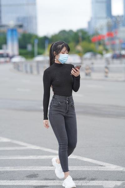 Black mid-neck slim T-shirt with dark gray high waisted jeans