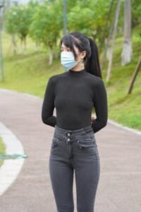 Black mid-neck slim T-shirt with dark gray high waisted jeans