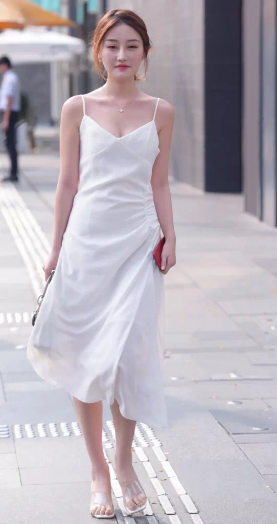 Knee-length white dress with transparent high heels