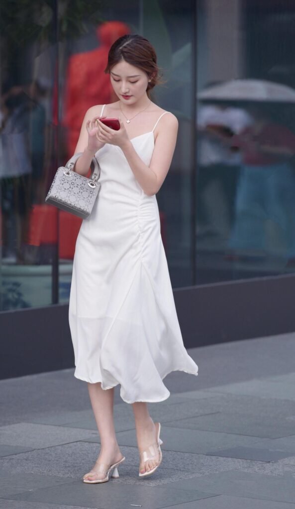 Knee-length white dress with transparent high heels